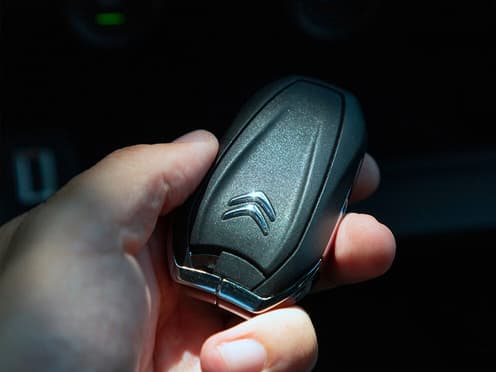 Une main tient la clé d'un Citroën reprise par Aramisauto.