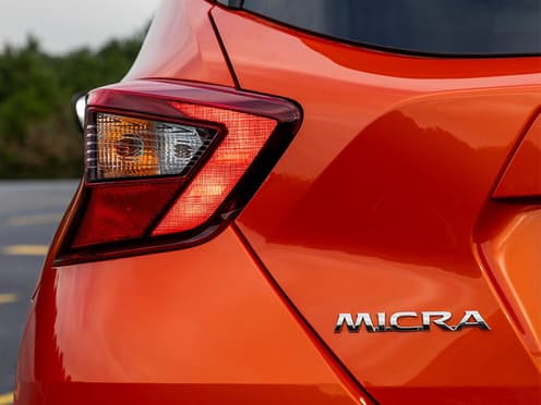 Zoom sur le phare arrière-gauche d'une Nissan Micra orange reprise par Aramisauto.